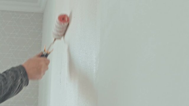 Handyman painting wall with background glue