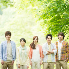 新緑の中で微笑む大学生