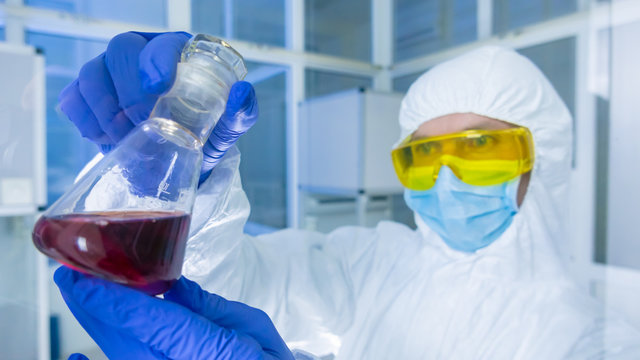 Chemistry lab - Researcher analyzing a liquid in a flask