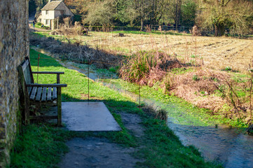 Bibury village in cotswolds and old houses with a chair outside