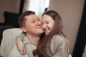 portrait of a happy father and beautiful daughter they laugh, indoor