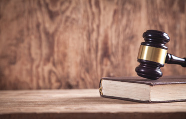 Judge gavel with Law book on a wooden table.