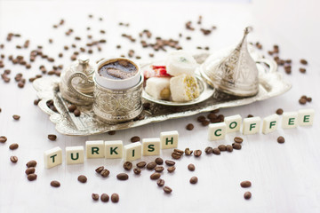 Fototapeta na wymiar Traditional Turkish coffee and sweets in silverware. Lettering Turkish coffee