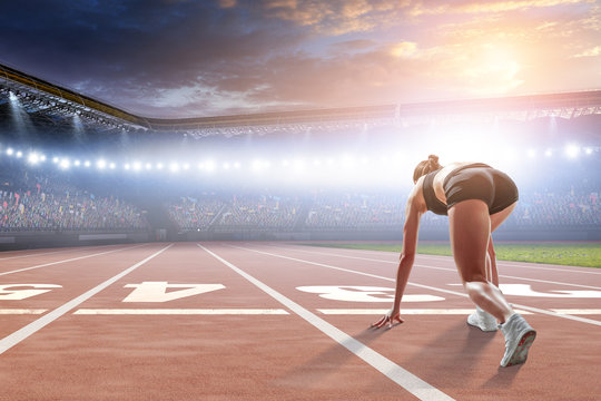 Woman sprinter start ready position on a stadium