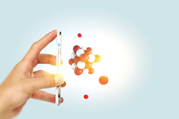 Businessman hand holding a smartphone with a bunch of spheres levitating beside. Mixed media