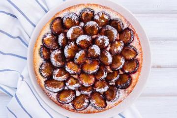 Homemade plum pie on the wooden background