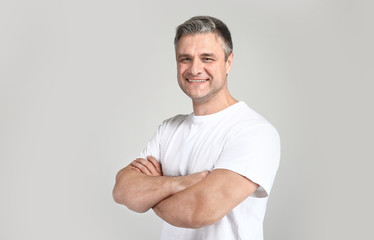 Portrait of handsome mature man on grey background