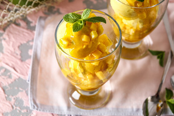 Glasses with tasty mango ice cream on table