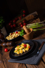 Fototapeta na wymiar crispy gnocchi with roasted asparagus and tomatoes