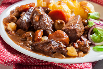 Beef Bourguignon stew served with baked potatoes