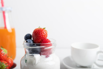 yogurt with fruit on a breakfast table on a white background