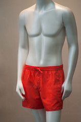 Closeup of orange summer short on mannequin in fashion store showroom