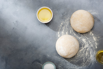 Risen or proved yeast dough for bread or pizza on a floured slate surface.