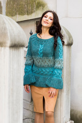 The woman in a pullover of manual knitting poses in the old city of Riga