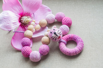 Necklace made from knitted beads and toys for the baby sitting in a sling.