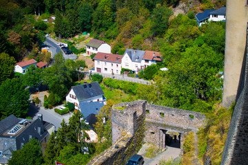 View of the wall of Vianden Castle and houses in the forest and mountain in Vianden, Luxembourg