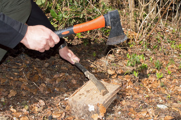 Close-up Man's Hands Cut Wooden Stick With An Ax