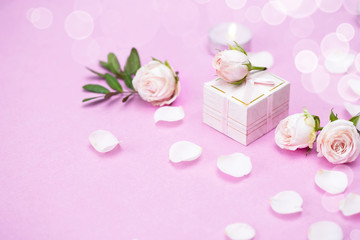 Rosebuds, petals,, gift box on a pink background. Concept for a greeting card. Weddings, Valentine's Day, Birthday