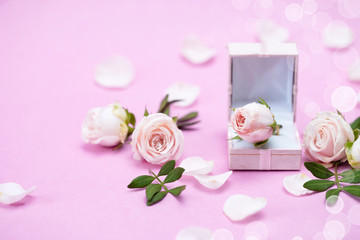 Rosebuds, petals,, gift box on a pink background. Concept for a greeting card. Weddings, Valentine's Day, Birthday