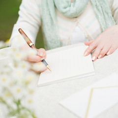 手紙を書くシニア女性の手元
