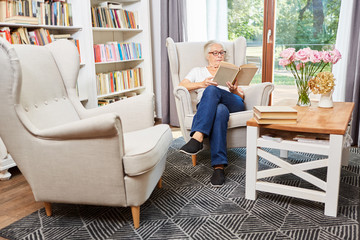 Seniorin liest konzentriert in einem Buch