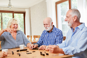 Senioren im Ruhestand spielen zusammen Domino