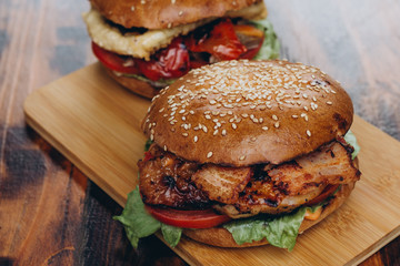 Homemade hamburger with fresh vegetables on wood table. Rustic background, copy space