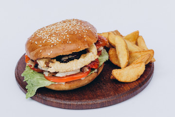 Big single burger with french fries isolated on white background