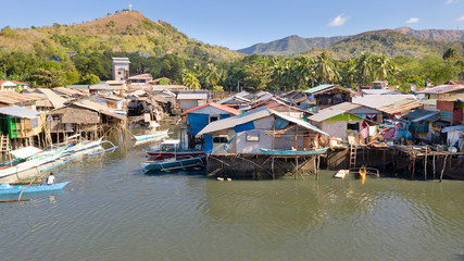 Fototapeta na wymiar Aerial view Coron city with slums and poor district. Palawan.Wooden houses near the water.Poor neighborhoods and slums in the city of Coron aerial view