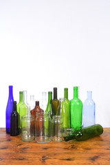 group of bottles and glass jars on a wooden table with white background