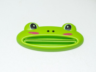 frog toothpaste squeezer on white background