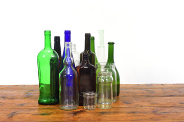 group of bottles and glass jars on a wooden table with white background