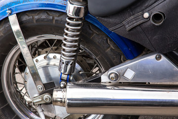 Parts of a racing motorcycle. Wheel, shock absorber and exhaust pipe close-up.