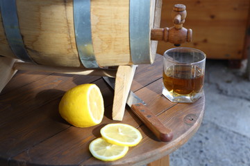 Brandy with lemon. A glass of brandy around an oak barrel