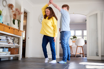 Young Downs Syndrome Couple Having Fun Dancing At Home Together