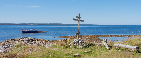 Wooden cross on shore of the White Sea at Anzersky Island. Solovky Islands, Russia