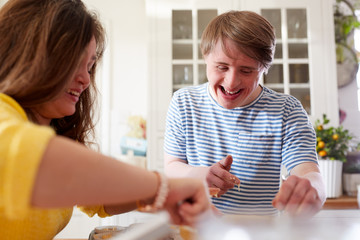Obraz na płótnie Canvas Young Downs Syndrome Couple Baking Cupcakes In Kitchen At Home