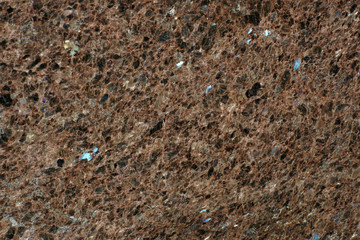 Background of natural stone granite brown with blue sparkles