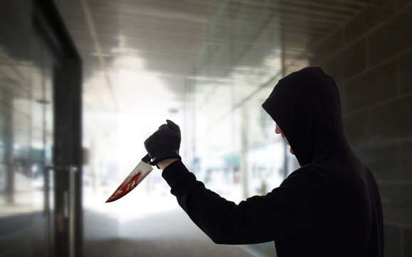 Crime Scene, Murder And Killing Concept - Close Up Of Criminal Or Murderer With Blood On Knife Over Dark Tunnel Background