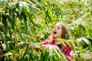 Fototapeta premium happy child in park. surprised kid in jungle. traveling concept. summer nature. Natural beauty. Childhood happiness. Spring holiday. Green environment. little girl spend free time in park