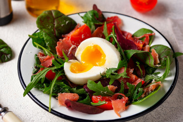 Healthy salad with prosciutto, tomato and egg