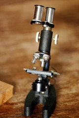 old retro microscope on a wooden table