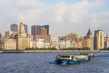 Obraz premium A household waste container ship is traveling on the Huangpu River on the Bund, a historic scenic spot in Shanghai