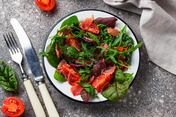 Healthy salad with prosciutto and tomato