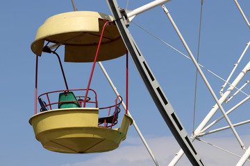Ferris wheel cabin on blue sky background. Damn wheel in amusement park