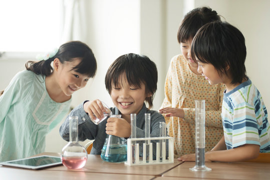 実験をする小学生 - Powered by Adobe