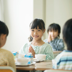 給食を前に手を合わせる小学生