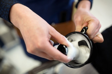 grooming and people concept - close up of barber's hands with brush making shaving foam at...