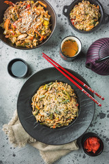Asian food set served on gray stone background, top view. Chinese, japanese and vietnamese cuisine, sushi, rice and noodle.