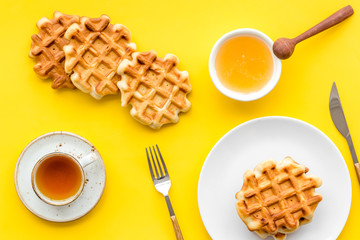 homemade Belgian waffles on served table on yellow background top view